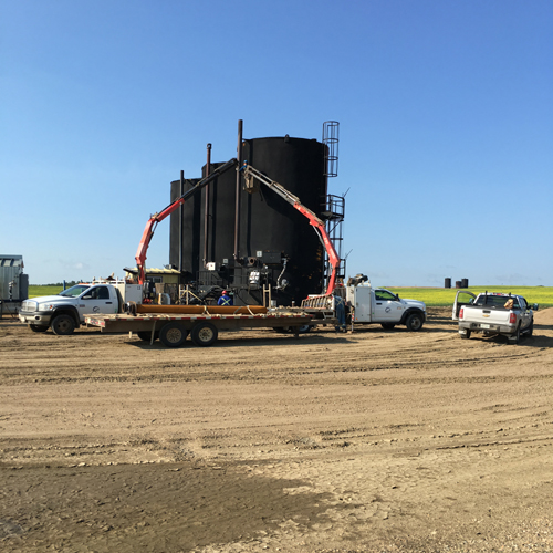 A truck is pulling a large black tank.