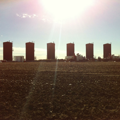 A field with some tall buildings in the background