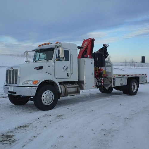 A white tow truck parked on the side of a road.