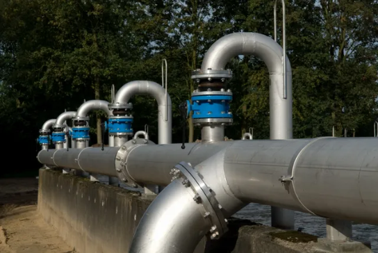 A close up of pipes on the side of a river